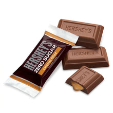 Cargar imagen en el visor de la galería, Piezas de chocolate Hershey's con relleno de caramelo y su envoltura individual sobre fondo neutro.